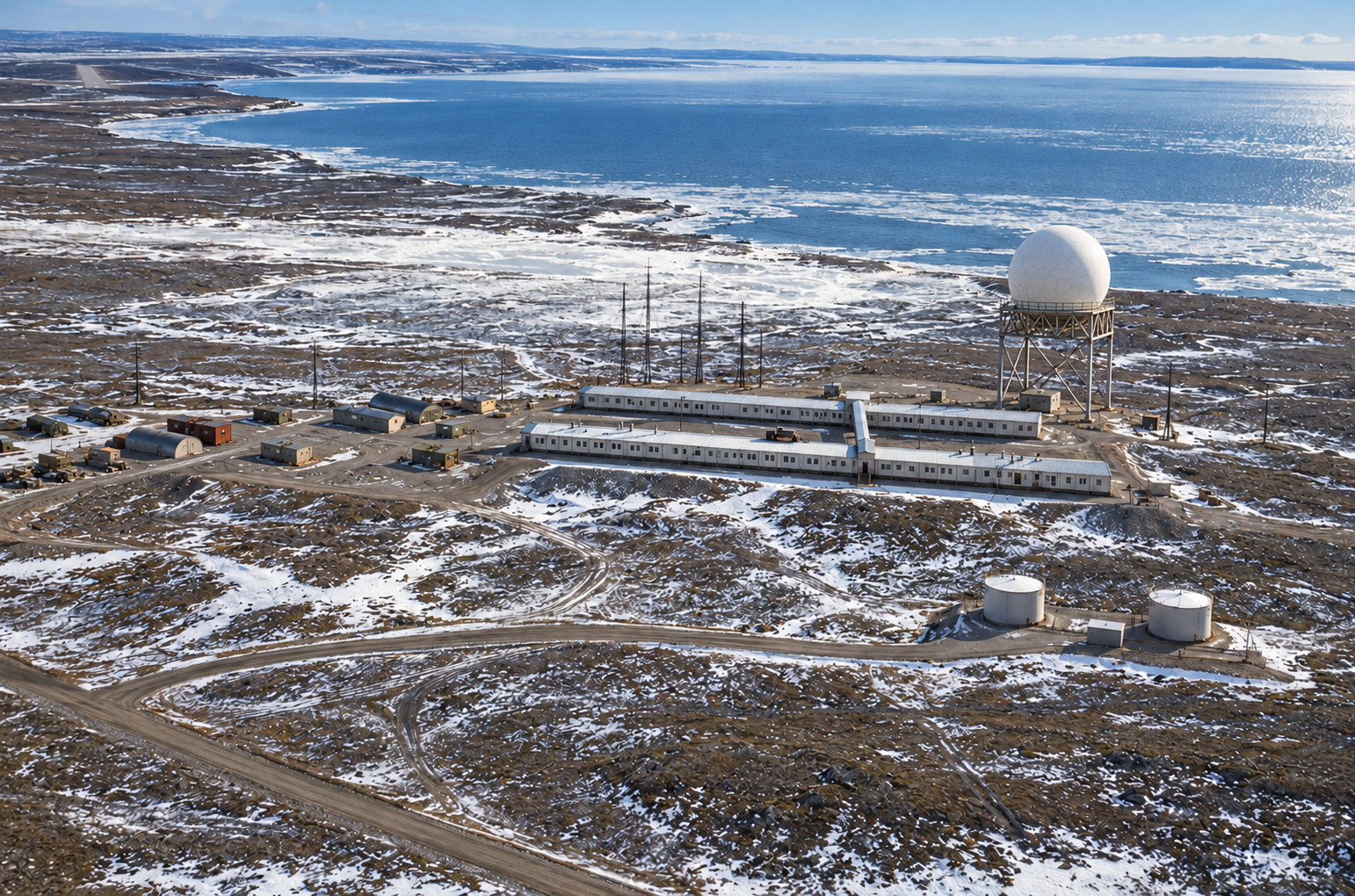 Interpretive aerial rendering of Cape Parry PIN-Main with two long parallel modular building trains, connecting passage, radome, smaller support buildings and the Amundsen Gulf coastline