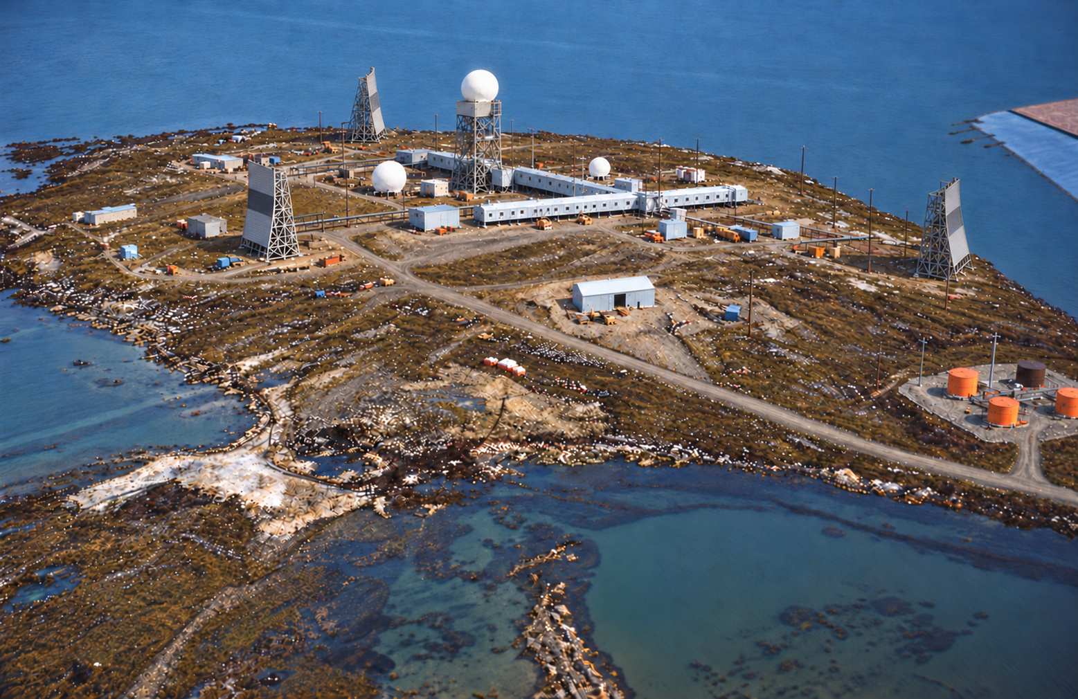 Interpretive aerial rendering of the historic Tuktoyaktuk BAR-3 DEW Line station on a low peninsula, with connected buildings, a white radar dome on an open steel support, three reflector panels, support buildings and fuel tanks
