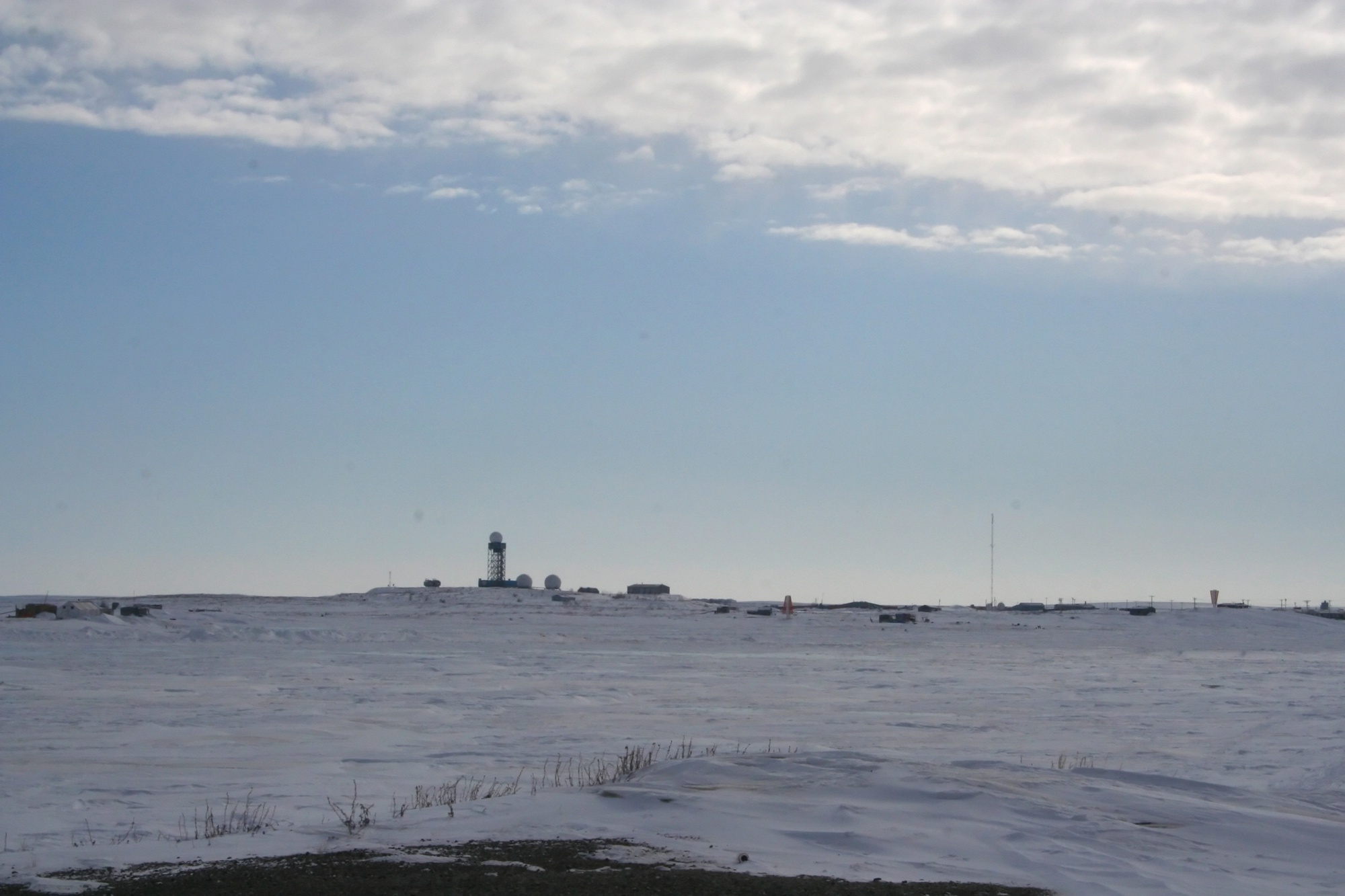Distant view of the Tuktoyaktuk North Warning System radar tower and low site buildings in snow in 2008