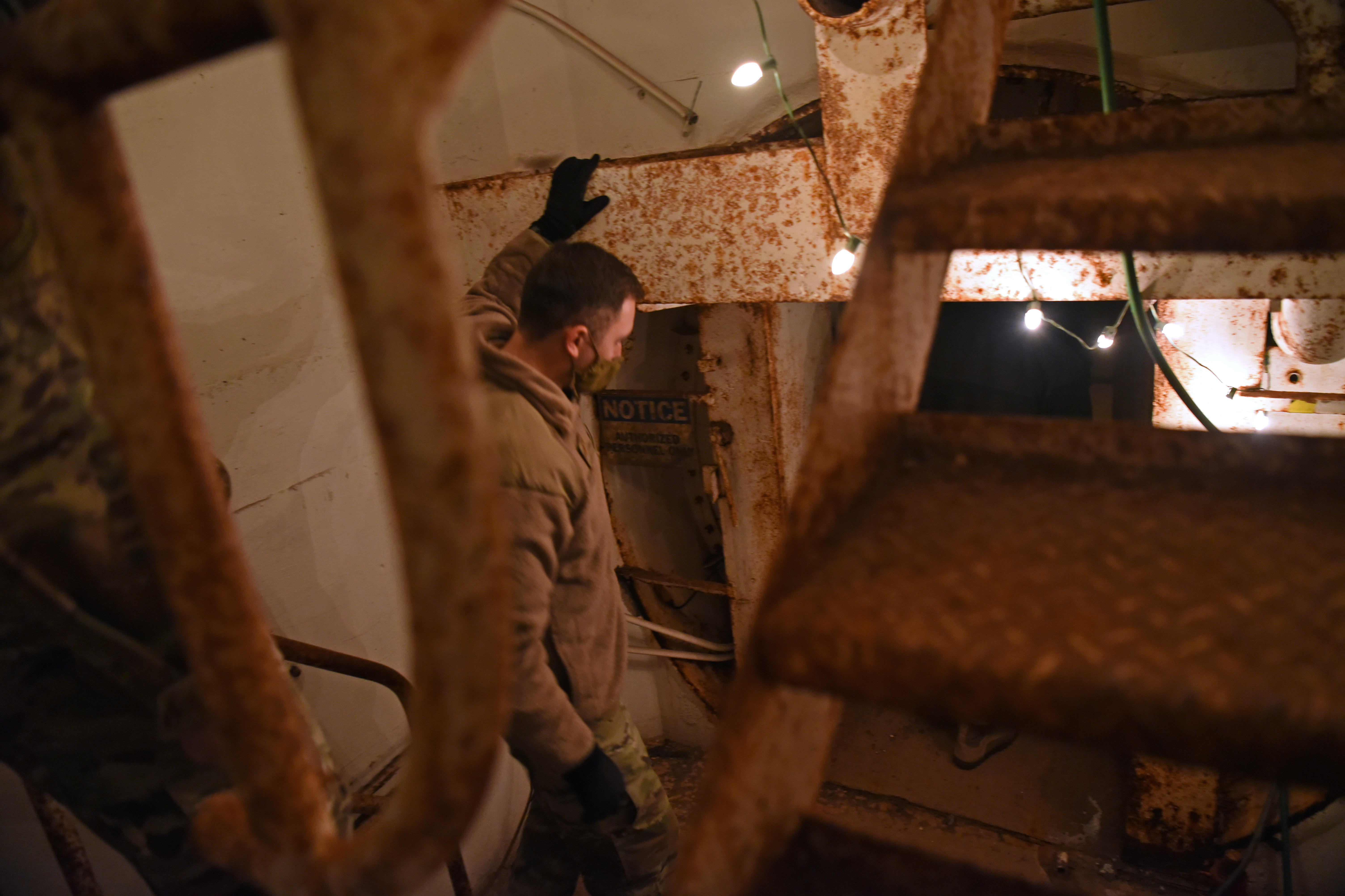 U.S. Air Force Maj. Joseph Newman, 17th Logistics Readiness Squadron commander, feels his way from the second level launch control center to the access tunnel to observe the 185-foot deep silo inside of Lawn Atlas Missile Base in Lawn, Texas, Dec. 3, 2020.