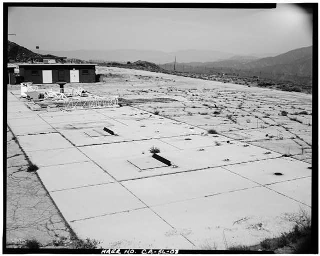 VIEW SHOWING STORAGE BUILDING ACROSS FROM LAUNCH PAD, WITH A SIDE VIEW OF AIR VENT