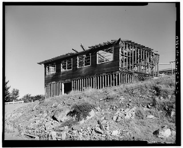 Mill Valley Early Warning Radar  EXTERIOR OBLIQUE VIEW OF THE PARTIALLY DESTROYED THEATER, BUILDING 203, LOOKING NORTHEAST.