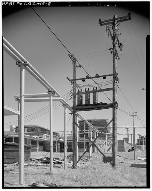 Mill Valley Early Warning Radar Station DETAIL VIEW OF THE POWER POLES, WITH BUILDING 204 IN THE CENTER DISTANCE, LOOKING NORTH.