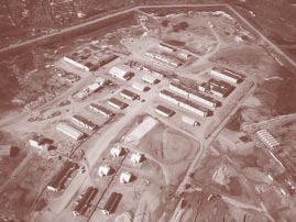 Archival aerial view of the developed Galena airfield complex, with rows of buildings, roads and hangars
