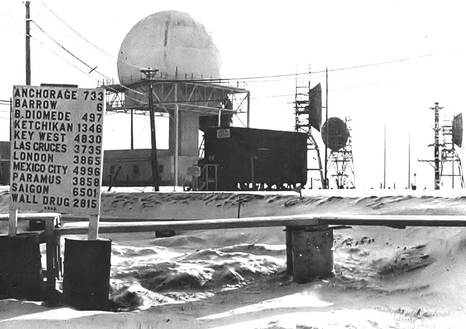 Historic Point Barrow radar site with elevated radome, modular station buildings and separate communications antennas in snow