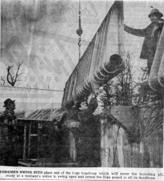 Newspaper photo showing installation of magazine doors at site D-06, Utica MI