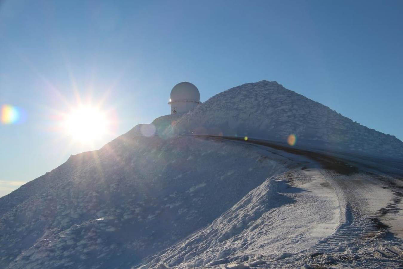 Snow-covered Alaska ridge with an AN/FPS-117 radar radome near its crest