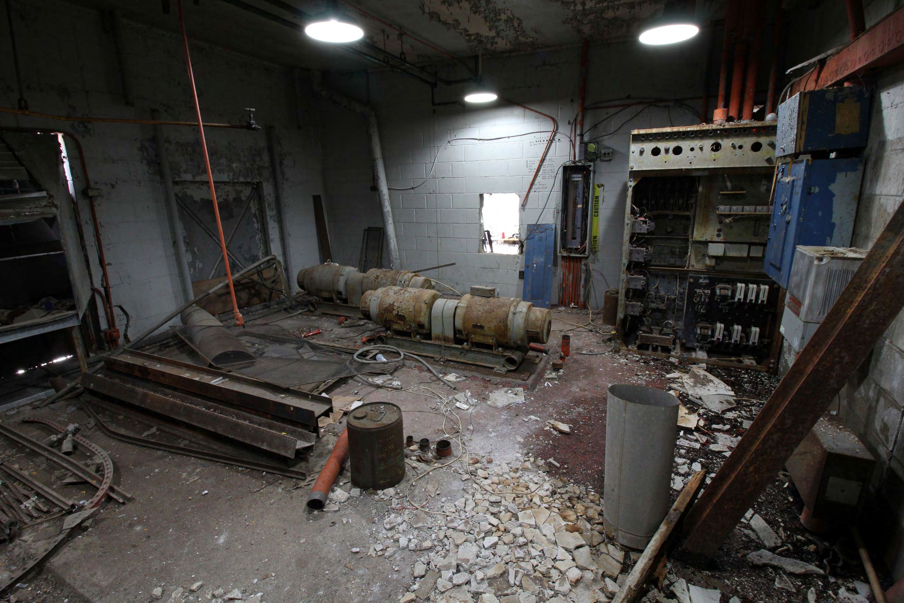 Generator room, rotary regulator motor generators and control panel, access hole in wall to equipment room, from east.